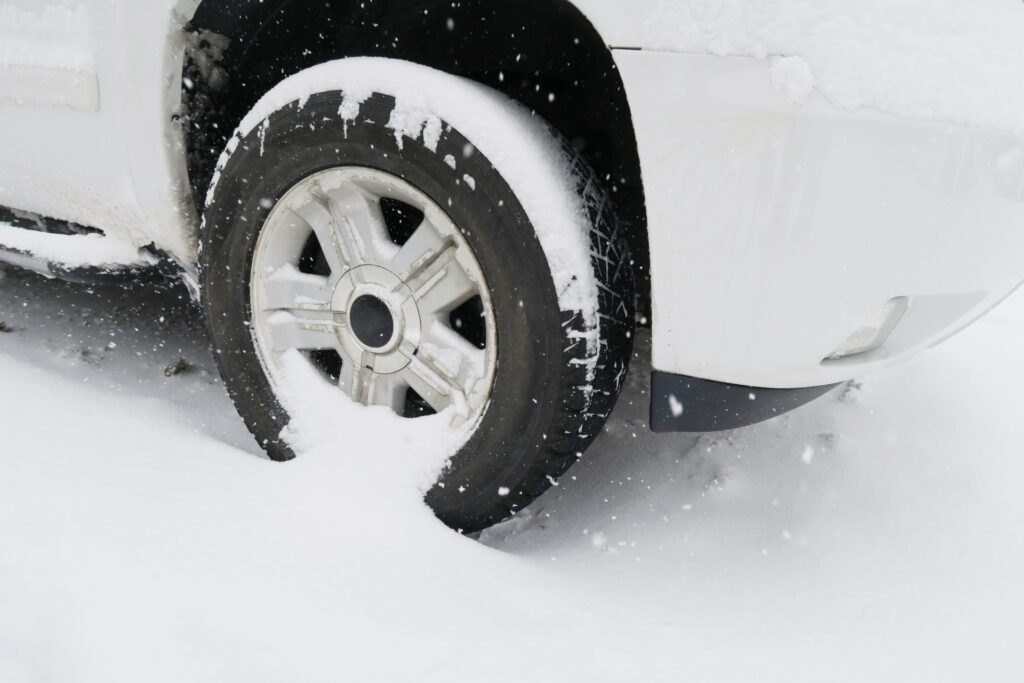 雪が積もったタイヤのアップと駐車場